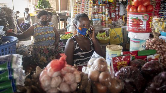 Woman in market in Accra, Ghana uses her cell phone