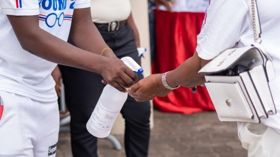 A woman has her hands sanitized at a political event in Accra, Ghana as part of coronavirus protocols