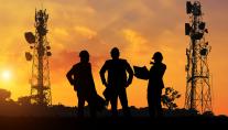 Silhouette of mobile network engineers at sunset.