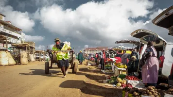 Cart puller in mask, Kenya. Elphas Nhuhi/GPSDD