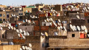 Satellite dishes of parabolic antennas on building roofs in Fes, Morocco. Credit: dsaprin via Shutterstock