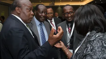 Four men and a woman engaged in conversation.