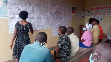 Women presenting score card findings to stake holders during a CVA meeting at Kaziba health center II, Kamwenge