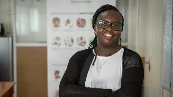 Dr. Evelyn Wesangula posing for a photo in a health office.