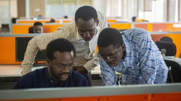 Three Ghanaian men looking at a computer
