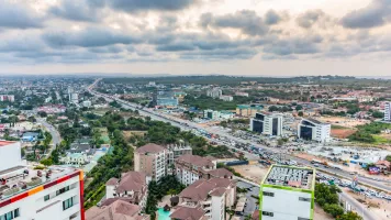 Aerial view of a city with clouds in the background.