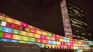 Bright colored squares illuminated on an L-shaped building against a dark sky.