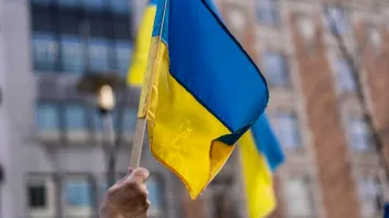 Ukrainian flag being held up towards the sky