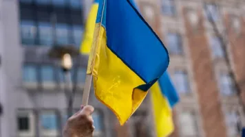 Ukrainian flag being held up towards the sky