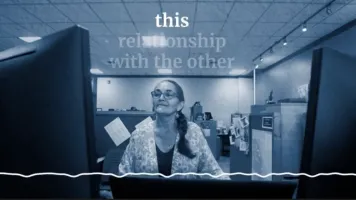 An image of a woman looking at a computer with a squiggly voice line and words in white appearing above her head.