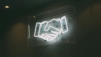 Neon sign of a handshake 