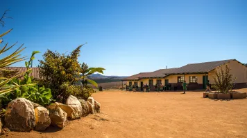 Wide angle shot houses built dry field few plants