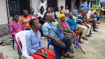 Elderly African Senior sitting on a Chair Stares at the Camera Waiting on a Queue