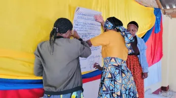 Village heads and community leaders sign their written commitments in Shona and English.
