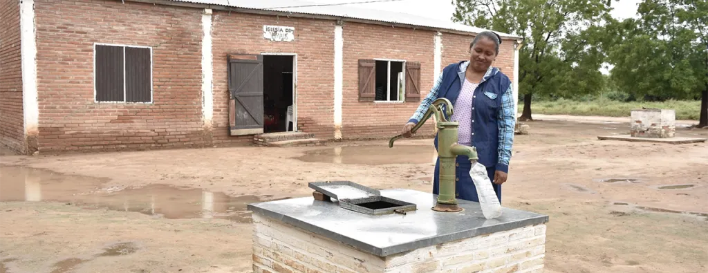 A woman collects water from a community well in Laguna Negra, an indigenous community in Paraguay
