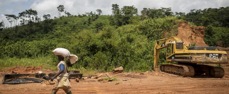 Man walking across a mining site in Ghana