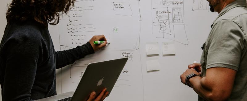 People writing on a white board