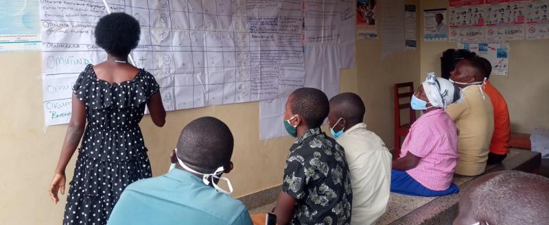 Women presenting score card findings to stake holders during a CVA meeting at Kaziba health center II, Kamwenge