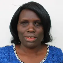 A black woman with short hair facing the camera. She appears to be blind.