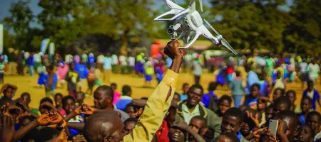 Residents of Kasungu, in central Malawi, gather during a demonstration of unmanned aerial vehicle (drone) technology. The Government of Malawi and UNICEF are testing the use of drones for humanitarian purposes. 28 June 2017. © UNICEF/UN070228/Chisiza