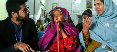 Naushad Bibi and her daughter-in-law talking to Muhammad Suleman (a data collector) at an eye hospital in Mandra, Pakistan. @Sightsavers/Jamshyd Masud.