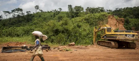 Man walking across a mining site in Ghana