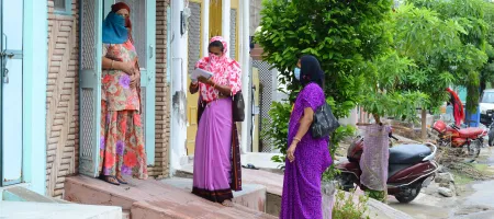 Anganwadi workers wearing mask interacts with a woman during a door-to-door survey to check the spread of novel coronavirus, on the outskirts of Beawar.