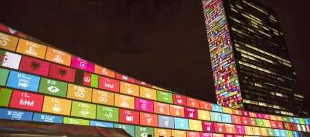 Bright colored squares illuminated on an L-shaped building against a dark sky.