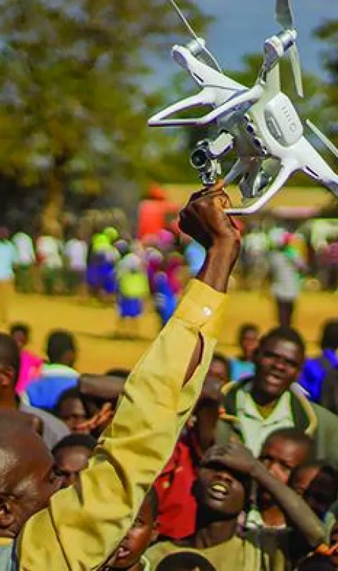 Residents of Kasungu, in central Malawi, gather during a demonstration of unmanned aerial vehicle (drone) technology. The Government of Malawi and UNICEF are testing the use of drones for humanitarian purposes. 28 June 2017. © UNICEF/UN070228/Chisiza