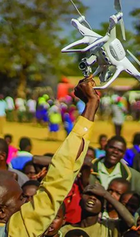 Residents of Kasungu, in central Malawi, gather during a demonstration of unmanned aerial vehicle (drone) technology. The Government of Malawi and UNICEF are testing the use of drones for humanitarian purposes. 28 June 2017. © UNICEF/UN070228/Chisiza