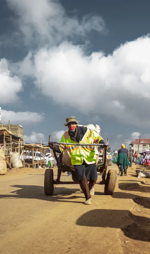 Cart puller in mask, Kenya. Elphas Nhuhi/GPSDD