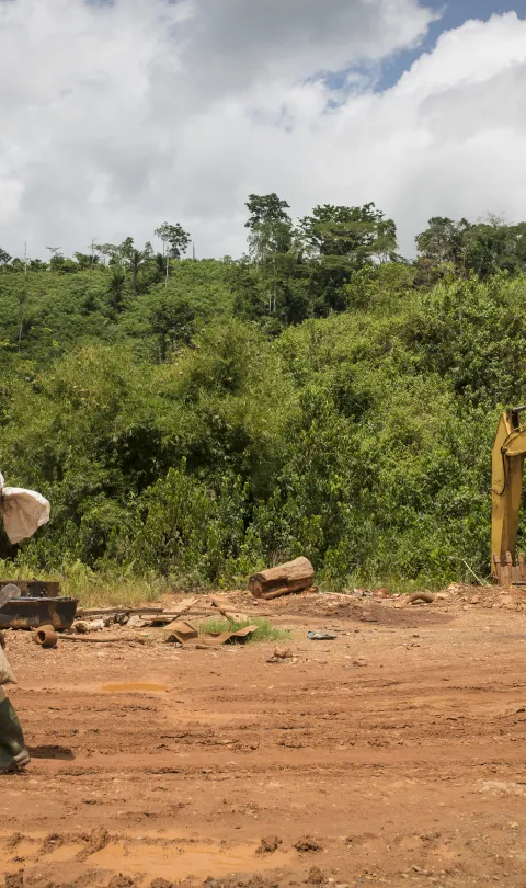 Man walking across a mining site in Ghana