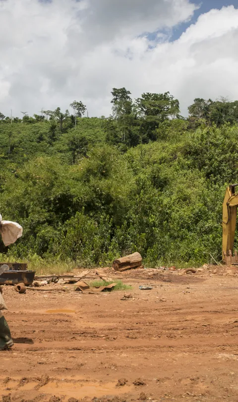 Man walking across a mining site in Ghana