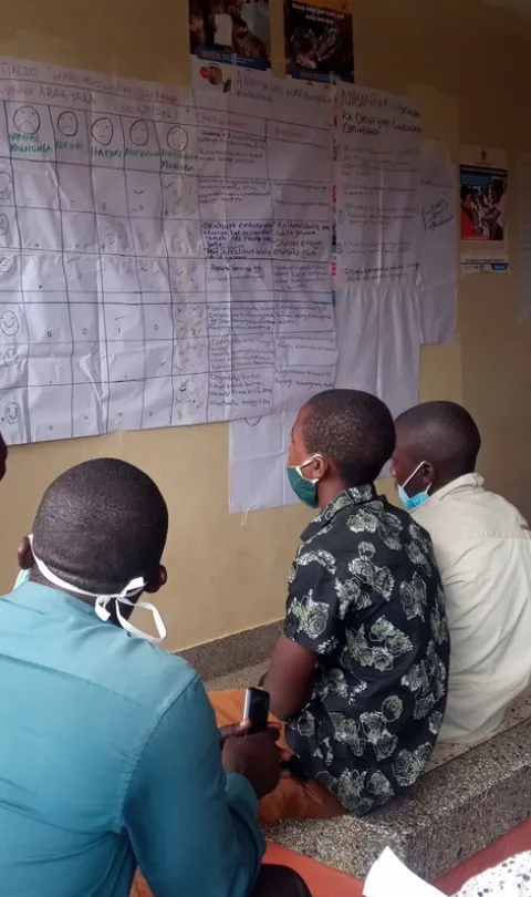 Women presenting score card findings to stake holders during a CVA meeting at Kaziba health center II, Kamwenge