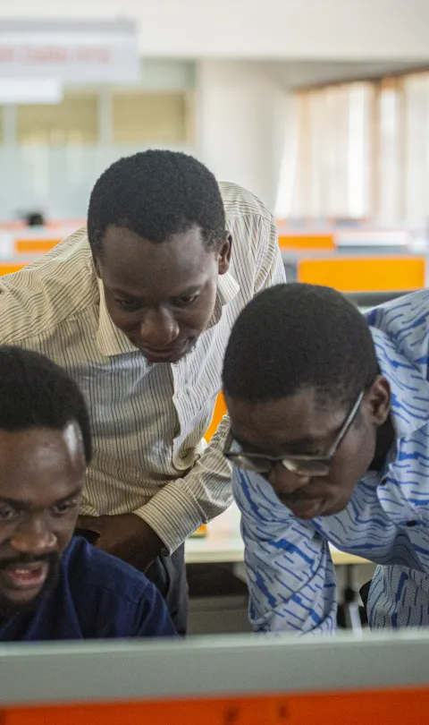 Three Ghanaian men looking at a computer