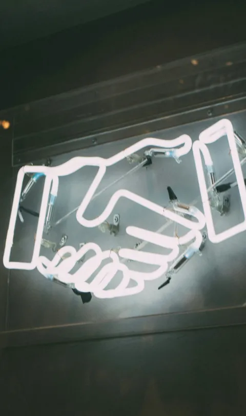 Neon sign of a handshake 