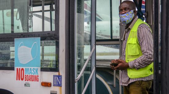 Airport staff member at the Lagos Airport stands at the door of a bus as domestic flights resume in Nigeria