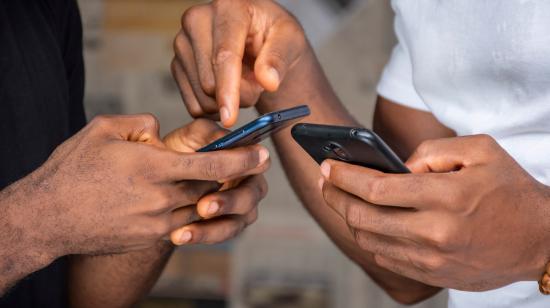 Shutterstock / two people exchanging information on mobile phones
