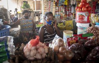 A seller at a food market in Accra, Ghana, uses her phone. Credit: Jordy Perdigo/GPSDD