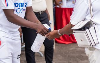 A woman has her hands sanitized at a political event in Accra, Ghana as part of coronavirus protocols