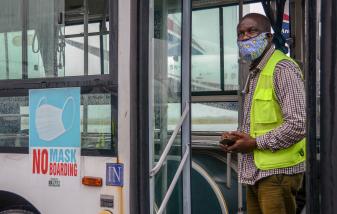 Airport staff member at the Lagos Airport stands at the door of a bus as domestic flights resume in Nigeria, Credit: Oluwafemi Dawodu/Shutterstock